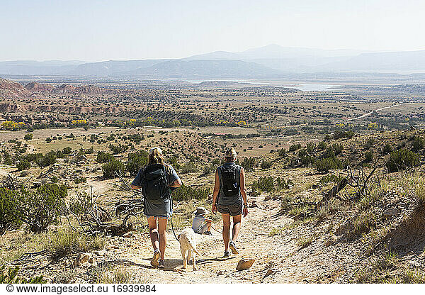 Drei Personen  Familie beim Wandern auf einem Pfad durch eine geschützte Canyonlandschaft