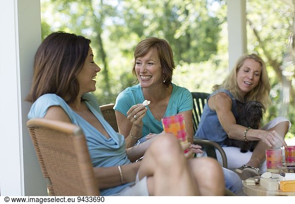 Drei reife Frauen beim gemeinsamen Essen und Trinken