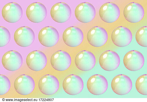 Dreidimensionales Muster von Reihen von Blasen vor buntem Hintergrund