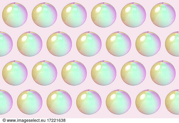 Dreidimensionales Muster von Reihen von Blasen vor rosa Hintergrund