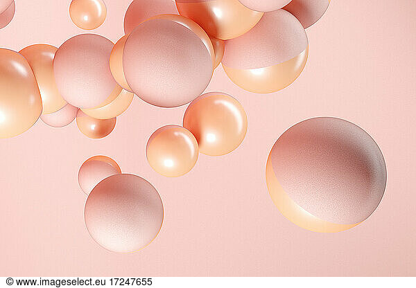 Dreidimensionales Rendering von rosa und orangefarbenen Kugeln  die vor einem rosa Hintergrund schweben