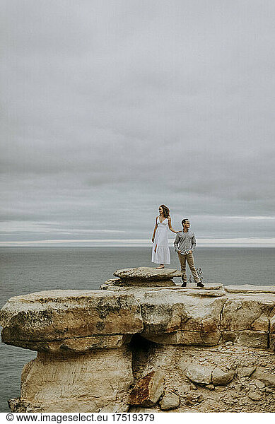 Dressed up couple stand on rock formation  Lake Superior  Michigan.