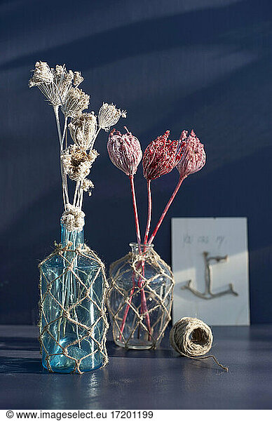 Dried flowers in vases decorated with macrame