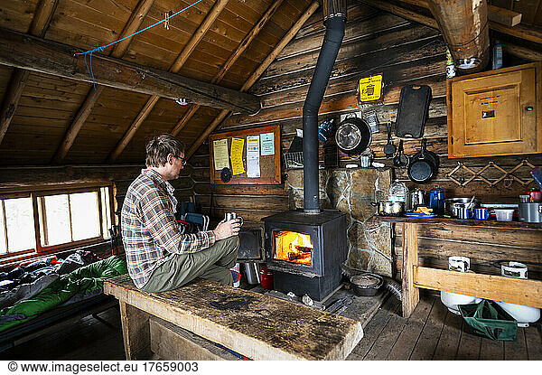 Drinking coffee with a fire inside the Snow Peak Cabin