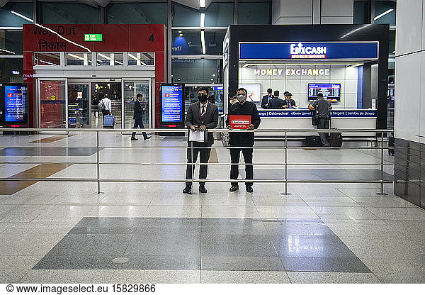 Drivers wearing face masks while they wait for arriving passengers at a practically empty arrivals lounge at Delhi airport  India.