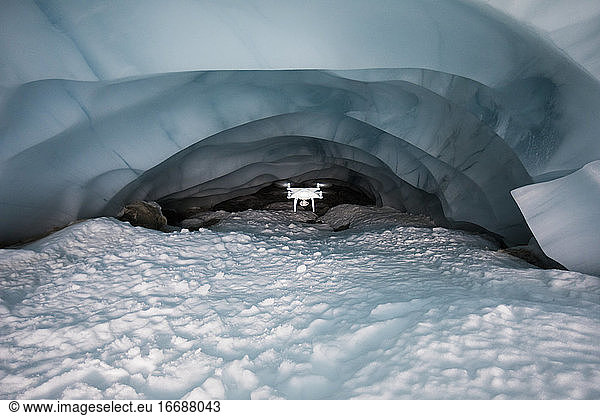 Drohne fliegt tief in eine Gletscherhöhle  um den Klimawandel zu dokumentieren.