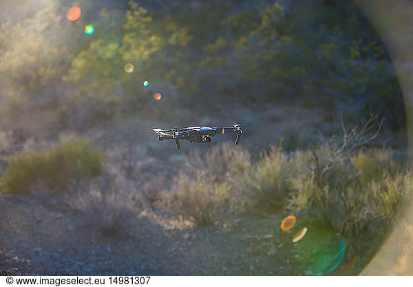 Drohne (unbemanntes Luftfahrzeug) fliegt in der Luft über aride Landschaft