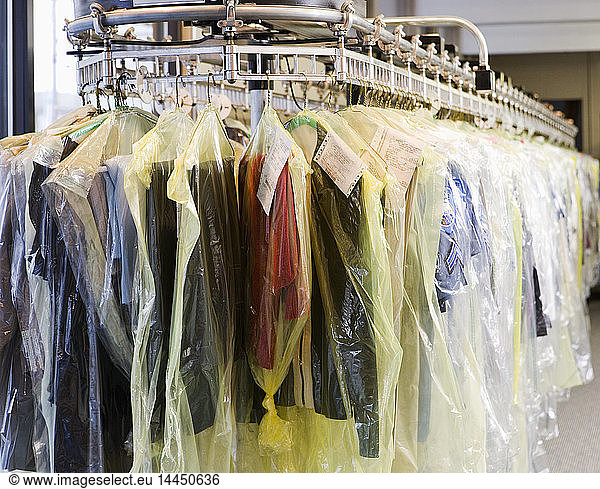 Dry cleaning wrapped in plastic on rack