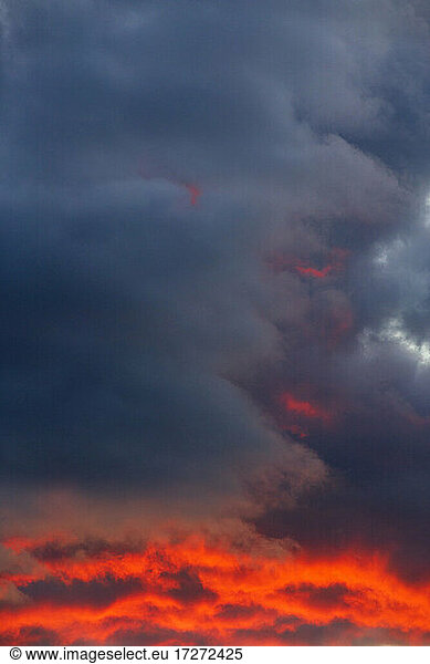 Dunkle Wolken von der untergehenden Sonne beleuchtet