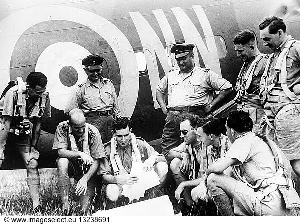 Dutch Air Force in British Malaya.. Dutch Air Force in British Malaya. Photograph shows ten Dutch and Royal Air Force officers discussing patrol plans alongside an airplane. between 1941 and 1942.