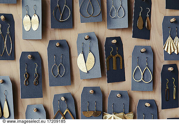 Earrings hanged on wooden rack at design studio