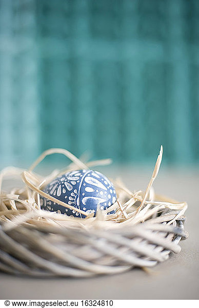 Easter decoration with wreath  straw and wooden egg