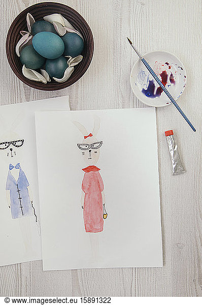 Easter eggs and two watercolor paintings of anthropomorphic Easter bunnies