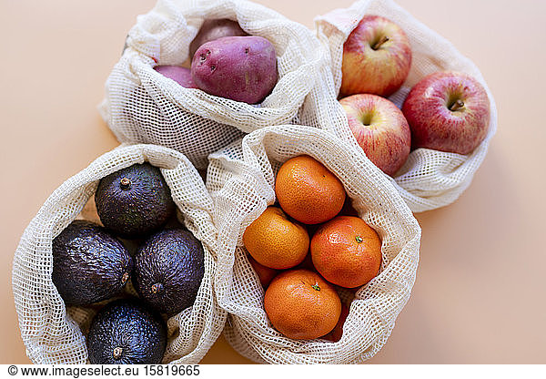 Eco-friendly reusable mesh bags with fresh fruits and vegetables