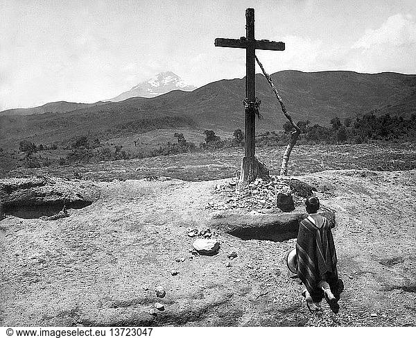 Ecuador: c. 1900 A devout wayfarer pauses before a lonely shrine on the road to Quito.