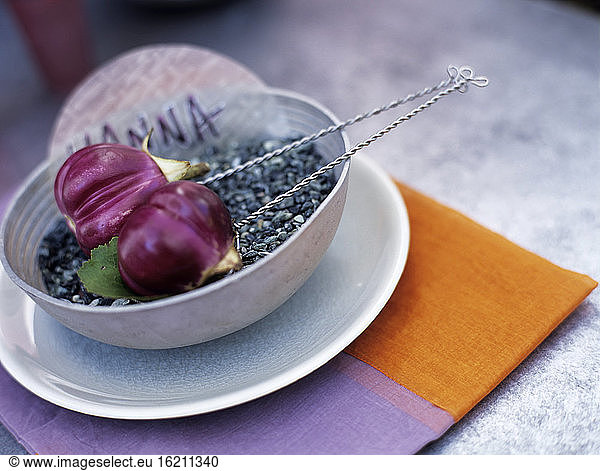 Eggplants on pebbles in bowl