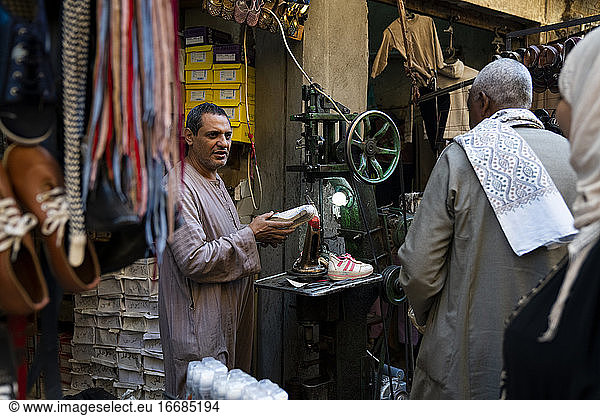 Egyptian man selling shoes in an outdoor market