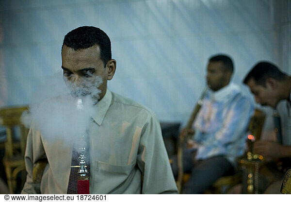 Egyptian men smoke shisha while playing backgammon at a cafe in Aswan  Egypt.