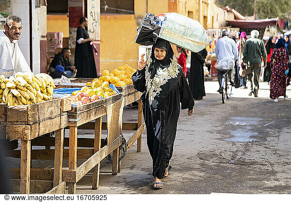 Egyptian woman walks through an outdoor market