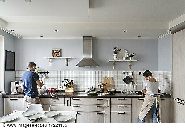 Ehemann und Ehefrau bei der Zubereitung von Speisen in der Küche zu Hause