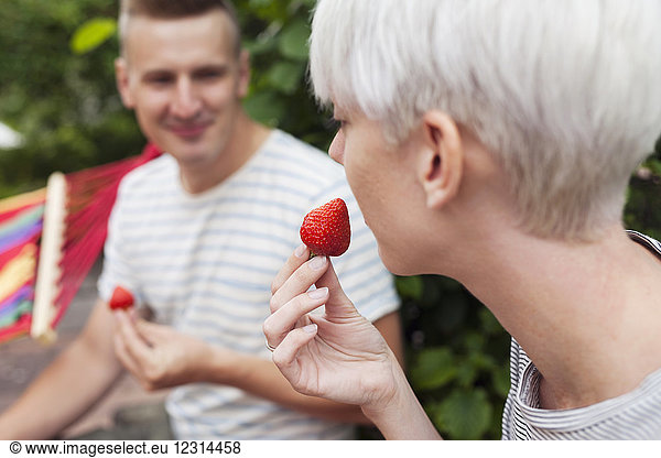 Ehepaar isst Erdbeeren im Garten