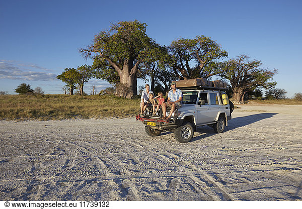 Ehepaar mit Söhnen auf Fahrzeug  Nxai-Pan-Nationalpark  Kalahari-Wüste  Afrika