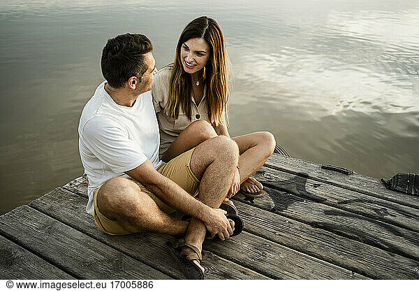Ehepaar sitzt am See am Steg
