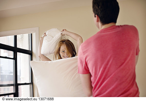 Ehepaar streitet zu Hause mit Kissen