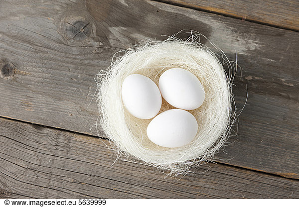 Eier im Nest auf Holztheke