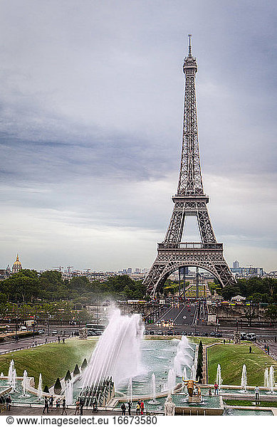 Eiffelturm in Paris mit grauem Himmel und einem Springbrunnen davor