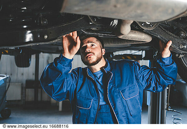 Ein Automechaniker prüft die Aufhängung eines Autos.