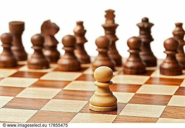 Ein Bauer gegen alle  hölzerne Schachfiguren auf einem Schachbrett. Selektiver Fokus  geringe Tiefenschärfe