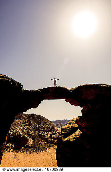 Ein Beduine posiert auf einem Felsbogen im Wadi Rum  NJordanien