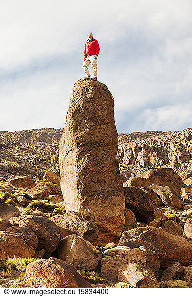 Ein Bergsteiger auf einem exponierten Gipfel in der Jebel-Sirwa-Region des Anti-Atlas-Gebirges in Marokko  Nordafrika.