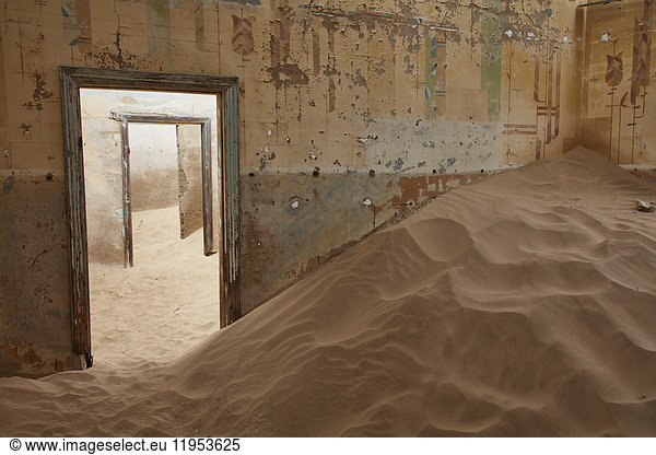 Ein Blick auf ein Zimmer in einem heruntergekommenen Gebäude voller Sand.