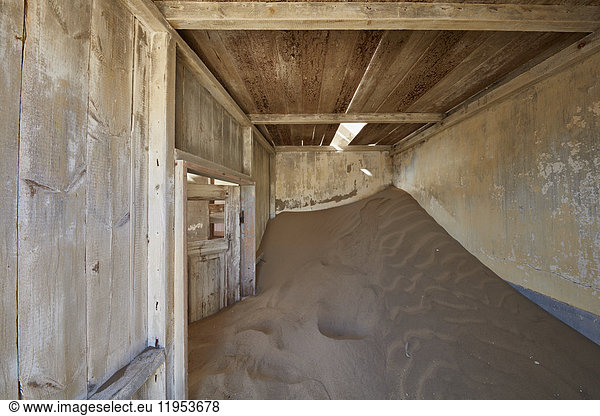 Ein Blick auf ein Zimmer in einem heruntergekommenen Gebäude voller Sand.