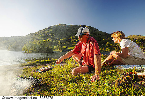 Ein Ehepaar beim Grillen an den Ufern des Rydal Water im Lake District  Großbritannien.