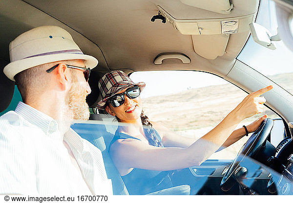 Ein Ehepaar  das in einem Lieferwagen unterwegs ist und auf sein nächstes Ziel hinweist.