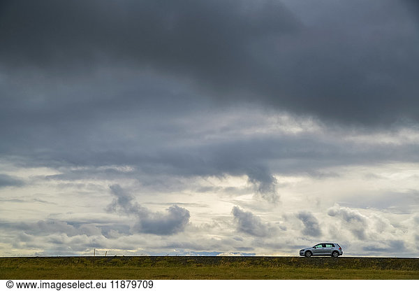 Ein einsames Auto fährt auf der Landstraße auf der Halbinsel Snaefellsness; Island'.
