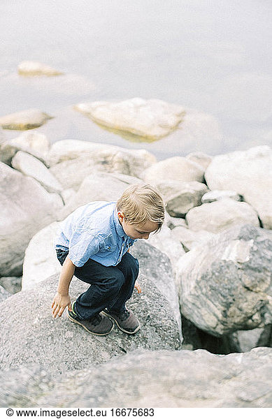 Ein fünfjähriger Junge klettert von Fels zu Fels