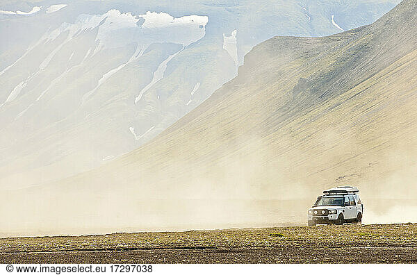 Ein Geländewagen fährt durch das staubige Landesinnere von Island