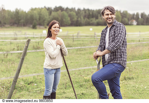 Ein glückliches  erwachsenes Paar  das auf einem Bio-Bauernhof arbeitet.
