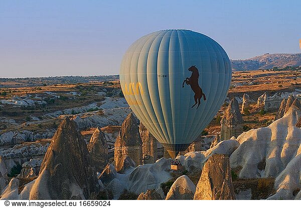 Ein Heißluftballon fliegt zwischen Tuffsteinfelsen über dem Goreme-Tal in Kappadokien  Türkei.