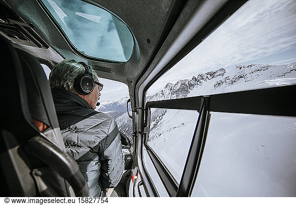 Ein Hubschrauberpilot fliegt hoch über schneebedeckte Berge in B.C.