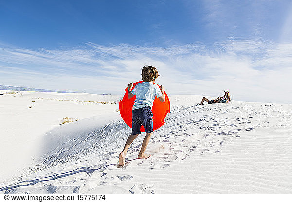 Ein Junge klettert auf Sanddünen