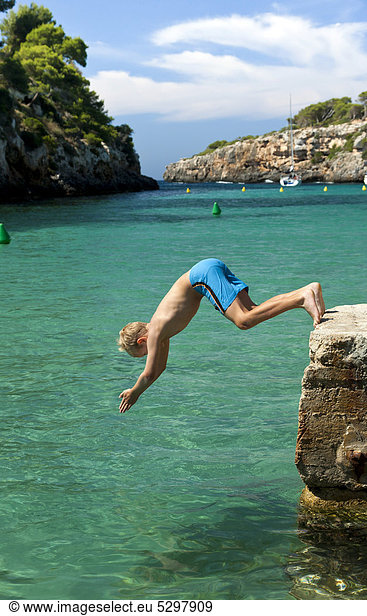 Ein Junge springt ins Meer  Kopfsprung  Cala Pi  S¸dk¸ste der Insel Mallorca  Balearen  Spanien  Europa