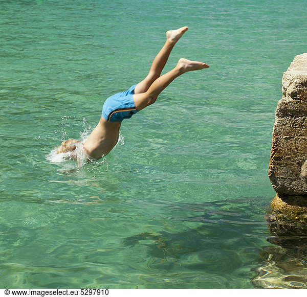 Ein Junge springt ins Meer  Kopfsprung  Cala Pi  S¸dk¸ste der Insel Mallorca  Balearen  Spanien  Europa
