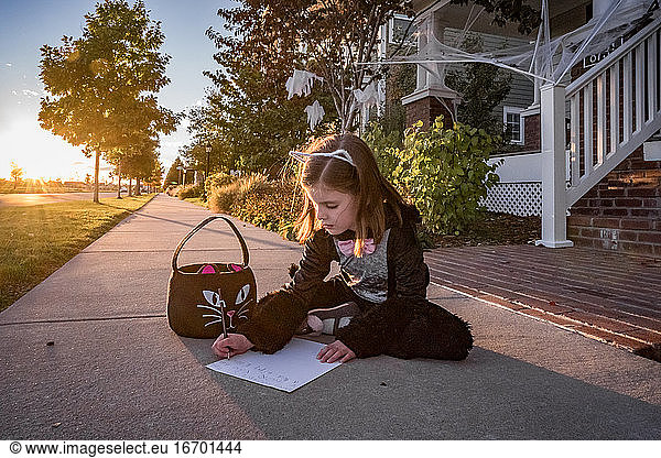 Ein junges Mädchen im Katzenkostüm schreibt einen Brief an die zahnlose Fee