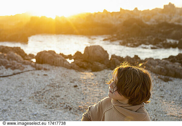 Ein kleiner Junge spielt am Strand zwischen den Felsen am Strand von De Kelders.