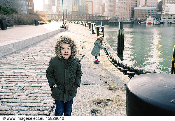 Ein kleiner Junge und seine kleine Schwester spazieren am Bostoner Hafen entlang.
